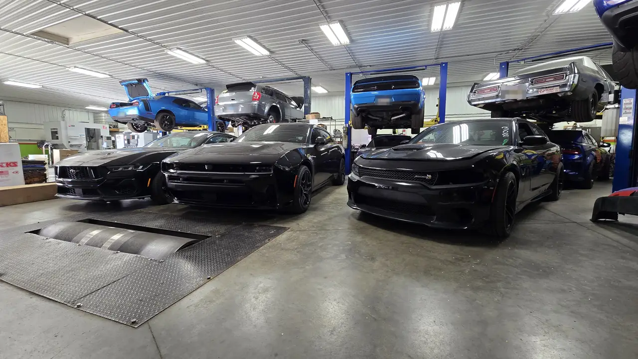 Ford Mustang, Dodge Charger Daytona and Charger Hellcat lined up by the chassis dyno at Satera Tuning
