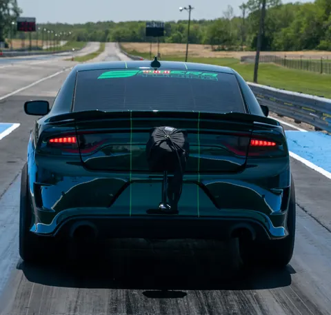 Rear of the Satera Tuning 1500whp Charger Hellcat shop car with its Satera Tuning window banner and parachute